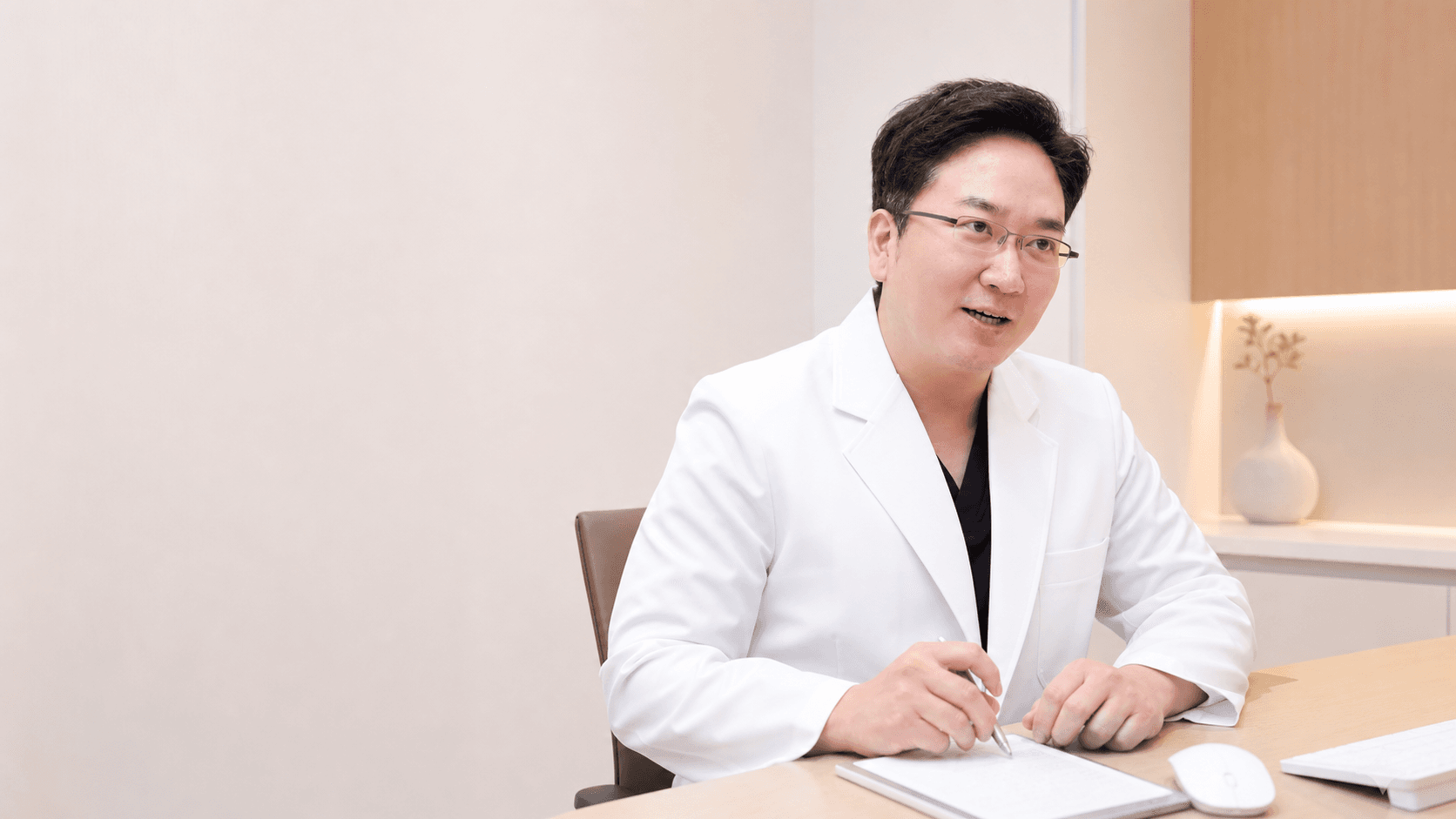 진료실 책상에서 상담하는 정준우 원장
